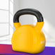 Yellow kettlebell with black handle on a purple and white striped surface