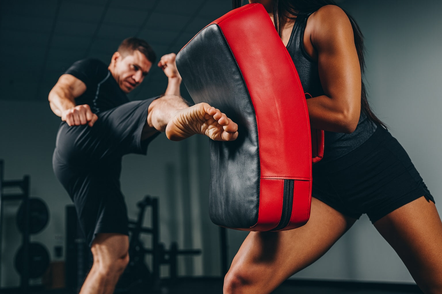 Person practicing martial arts with a red and black target in a gym setting