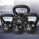 Set of black kettlebells with weight markings on a blurred background