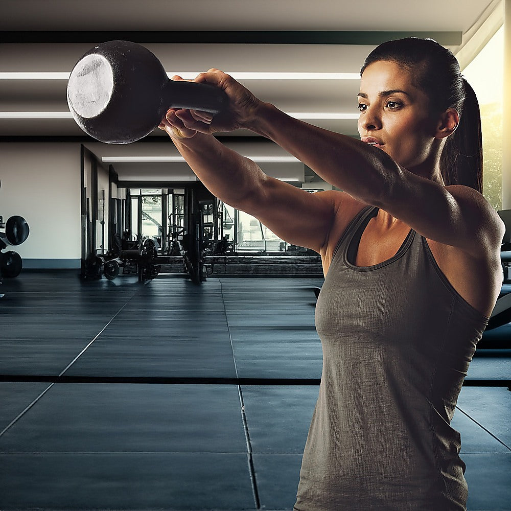 Woman lifting a dumbbell in a gym setting